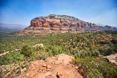 Büyük renkli kayalar yeşil ağaçların üzerinden yükseliyor Devils Köprüsü