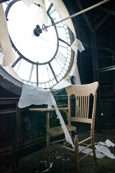 Antyczne krzesło szkolne siedzące wewnątrz opuszczonej wieży zegarowej — Zdjęcie stockowe
