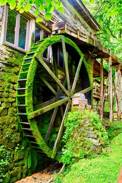 Водяное колесо по течению вертикально покрыто зеленым мхом — стоковое фото