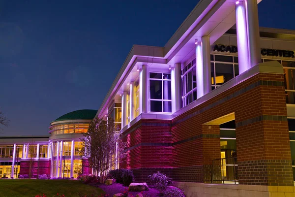 黄昏时分，许多窗户点亮了紫色的现代建筑的虫眼 — 图库照片