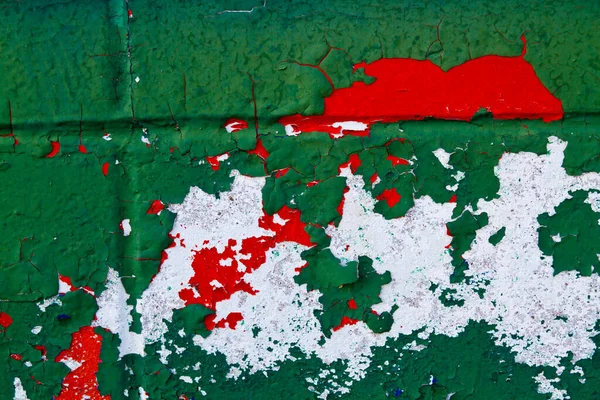 Бетонна стіна пофарбована в зелений білий і червоний колір, який лущиться з віком — стокове фото