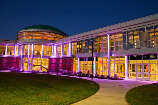 Yet another angle of the modern building with many windows at twilight lit up purple — Stock Photo, Image