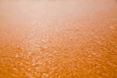 Kumlu bir plaj arka planında akan suyun yakın çekimi