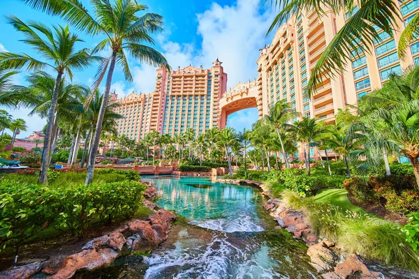 Palmiye ağaçları ve oteli olan tropikal tatil beldesindeki nehir manzarası