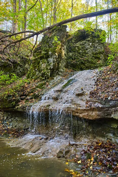 Vertikální vodopád kapající vedle velkých skal — Stock fotografie