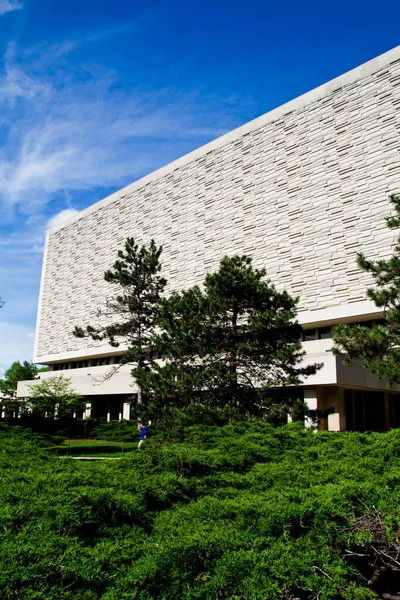 อาคารห้องสมุดสีขาวสูงที่มีต้นไม้และพุ่มไม้ในพื้นหน้า Wells ห้องสมุด — ภาพถ่ายสต็อก