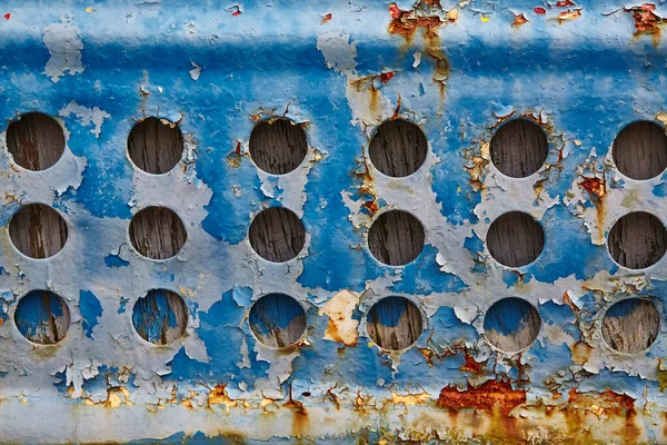 Εγκαταλελειμμένη σχάρα με σκουριά και ξεφλούδισμα μπλε χρώματος γύρω από τις τρύπες — Φωτογραφία Αρχείου