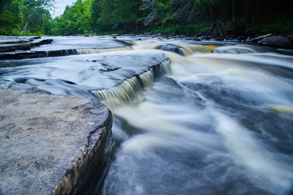 Kleine watervallen boven grijze rotsen in het bos — Stockfoto