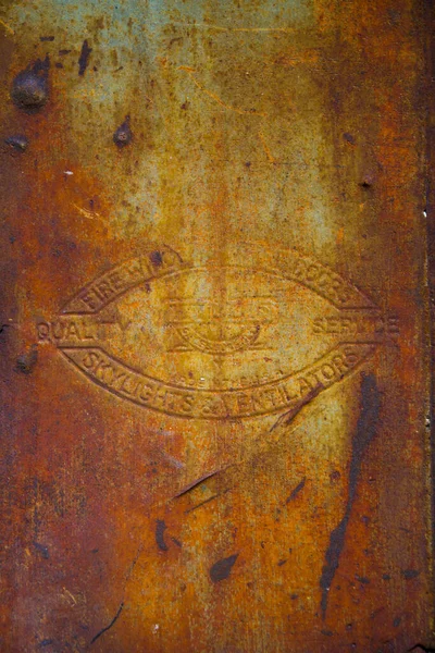 Sfondo in metallo antico arrugginito con vecchio simbolo in rilievo — Foto Stock