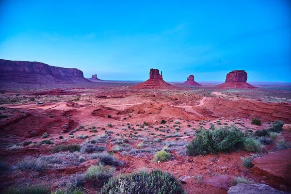 Büyük kırmızı kayalar ve mavi renklerden oluşan çöl manzarası — Stok fotoğraf