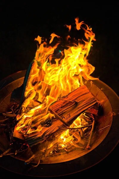 Fuego rojo y naranja ruge en una fosa de fuego de metal — Foto de Stock