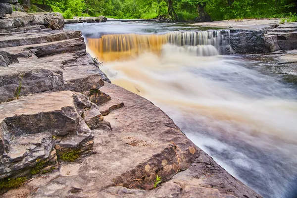 Närbild av stenar bredvid ravinen med vattenfall — Stockfoto