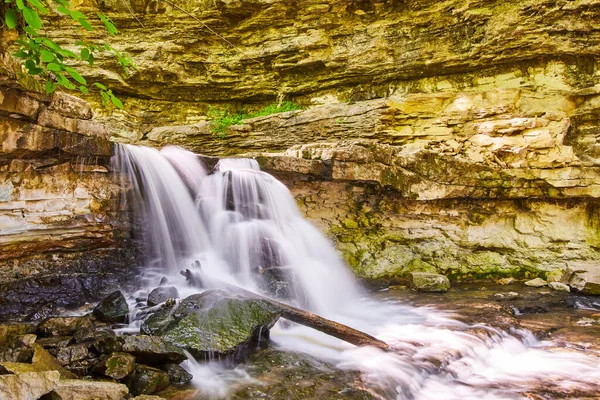 Vitt vattenfall stänk av stenar i ravinen — Stockfoto