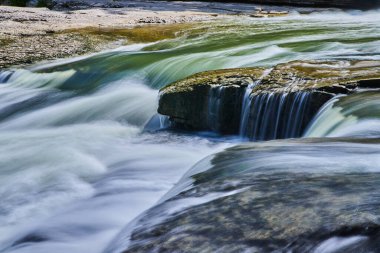 Nehirdeki çağlayan şelalelere yakın.