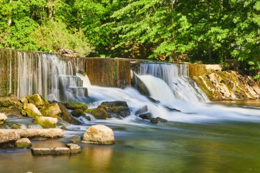 Yosunlu kayaların üzerinde şelaleli baraj