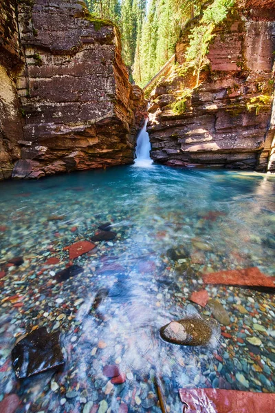 Waterval snijden door steile kliffen in ongerept blauw water met kleurrijke rotsen — Stockfoto