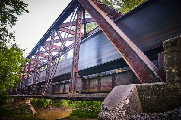 Alte Eisenbahnbrücke aus Metall über Fluss mit verschwommenem Bahnübergang — Stockfoto