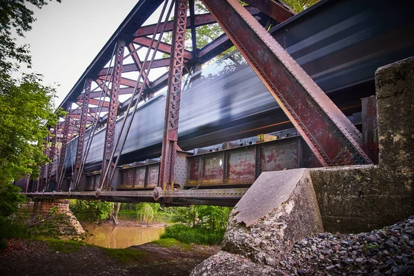 Desfoque do comboio que passa por uma grande ponte metálica — Fotografia de Stock