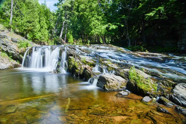 Красиві водоспади в зеленому лісі над скелястим схилом — стокове фото