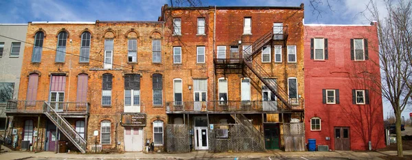 Kolorowe, połączone ceglane budynki ze schodami pożarowymi i licznymi oknami — Zdjęcie stockowe