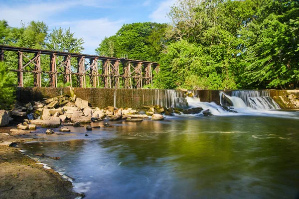 Grote dam blokkeren rivier en het creëren van watervallen met spoorbrug op de achtergrond — Stockfoto