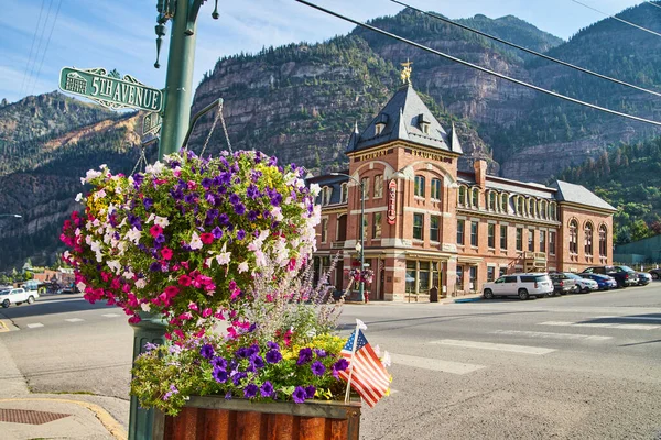 Montanha cidade cruzamento com flores penduradas e em vasos — Fotografia de Stock