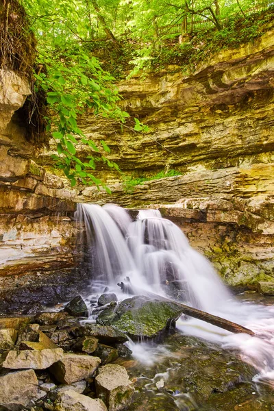 Klipp med vattenfall skapar ravin som vatten stänk mot block och stock — Stockfoto