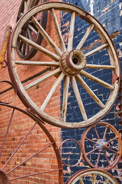 Vieilles roues de chariot en collage contre bâtiment en brique — Photo