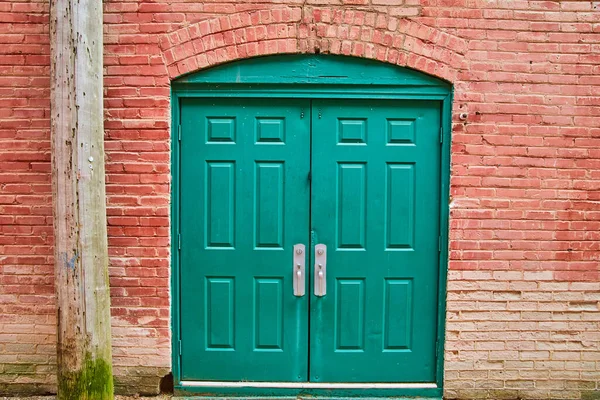 Callejón doble puerta verde con ladrillo rojo Fotos de stock