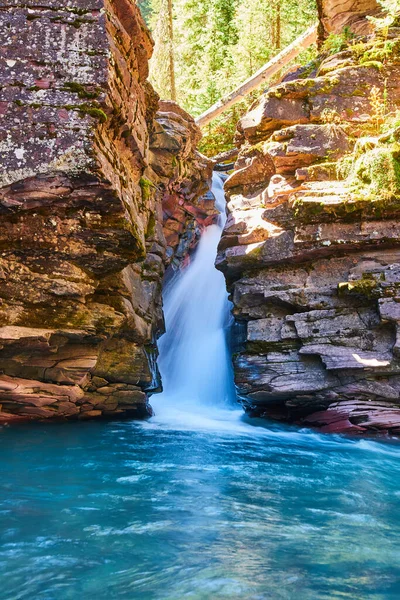 Falésias íngremes cobertas de líquen com cachoeira e água azul — Fotografia de Stock
