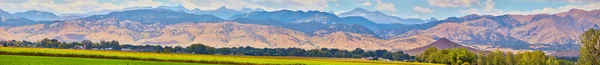 Panorama della grande catena montuosa con campo agricolo in primo piano — Foto Stock