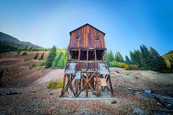 废弃的旧木矿建筑陷落在空旷的山里 — 图库照片