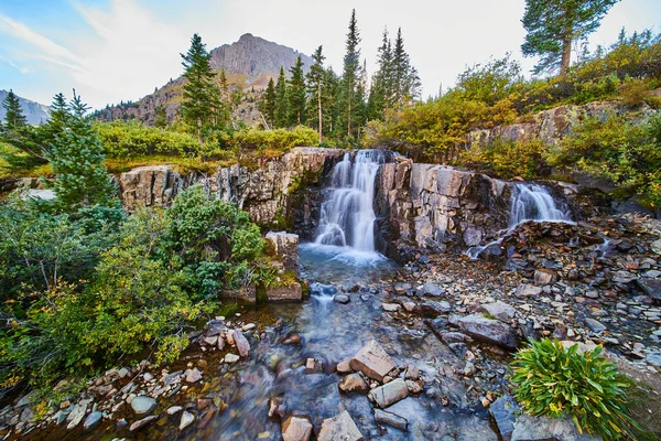 Vista de hermosas cascadas en el lecho del río poco profundo con montañas en el fondo —  Fotos de Stock