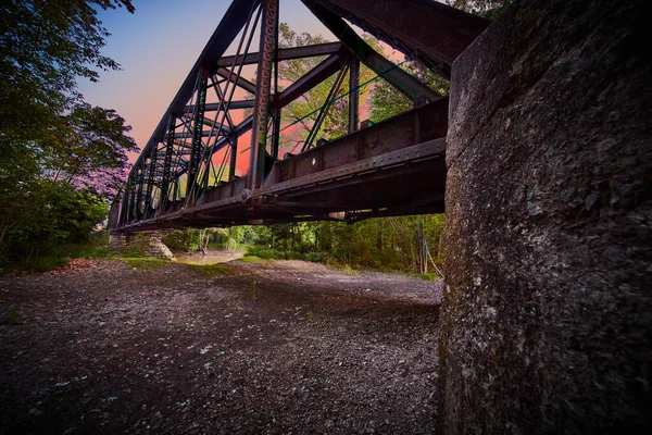 Vista da ponte supporto per binari ferroviari con intenso tramonto colore rosa — Foto Stock