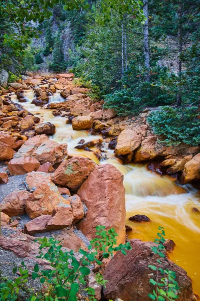 Cascades descendant en cascade une petite rivière bordée de grandes roches rouges — Photo