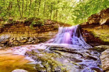 Kayalık uçurumlarla dolu ormanda canlı bir şelale