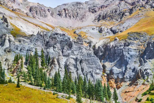 Grijze bergketen met kolommen van rotsen en pijnbomen aan de voet — Stockfoto