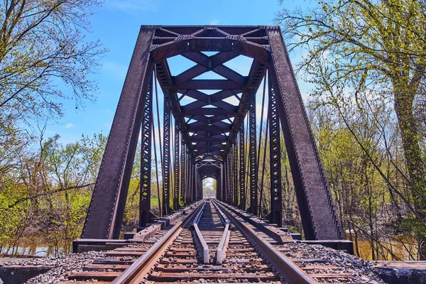 Закрыть железнодорожные пути старым мостом через воду — стоковое фото