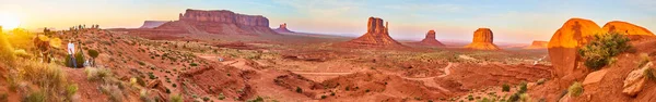 Panorama of photographers at sunset next to Monument Valley with large red rocks — Stock Photo, Image