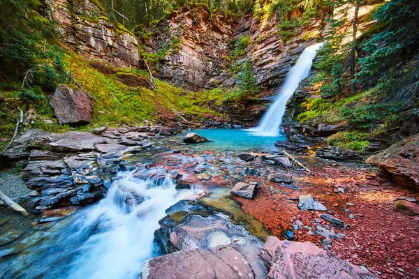 Majestuosa y vibrante cascada secreta en el cañón con agua azul y coloridas rocas rojas —  Fotos de Stock