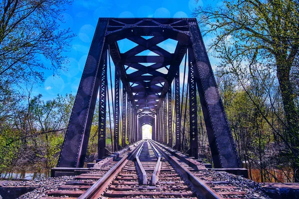 Железнодорожные пути через старый мост с ярким светом в конце — стоковое фото