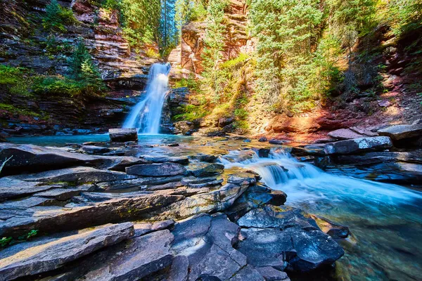 Яскрава блакитна вода і водоспад в ущелині з ярусами каміння — стокове фото