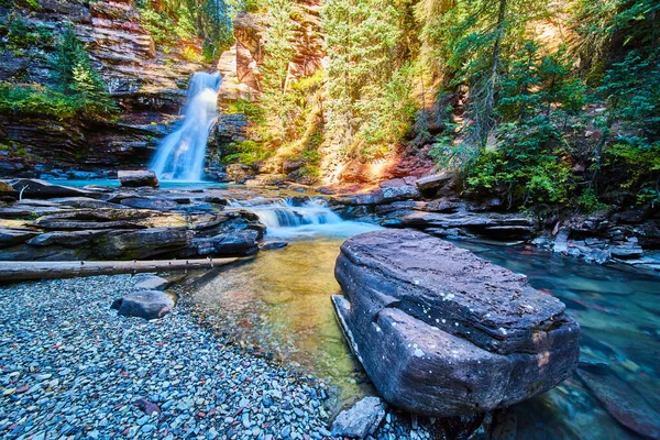 Pedra grande no leito do rio pela majestosa cachoeira azul no cânion — Fotografia de Stock