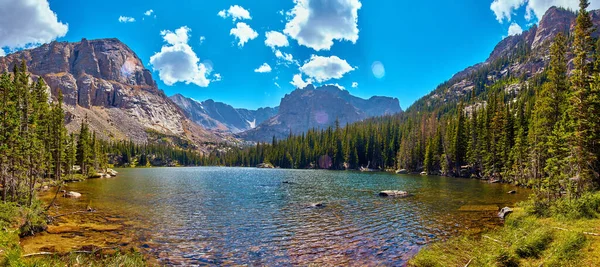 Gyönyörű elszigetelt tó betűrve hegyekbe fenyőfákkal körülvéve — Stock Fotó
