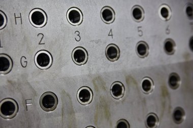 Üzerinde numaralandırılmış portlar ve karanlık delikler olan metal tahta