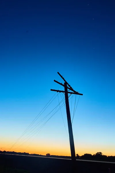 Silhuett av en telefonstolpe i skymningen — Stockfoto