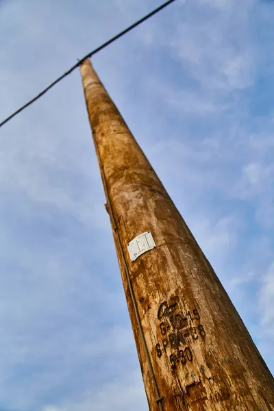 Pólo de telefone marrom desbotada que se estende até um céu azul — Fotografia de Stock