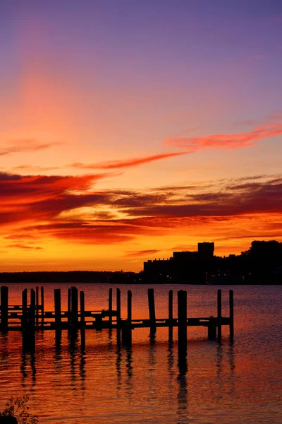 Золотой красный восход солнца с доками, сидящими в рифе с рябью воды — стоковое фото