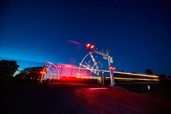 Залізничний перехід і швидкісний поїзд у русі в сутінках — стокове фото