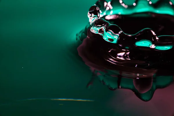Koruna zelené a fialové vody vytvořená z kapky vody, která vypadá jako jed — Stock fotografie